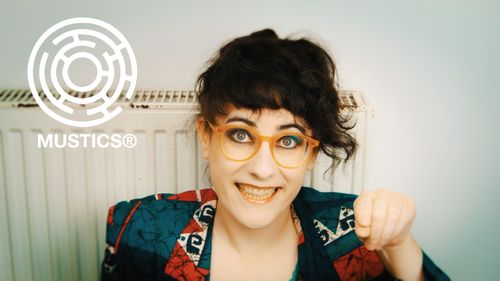 Meljoann poses in front of a radiator, pointing at you rudely, with an inviting smile.